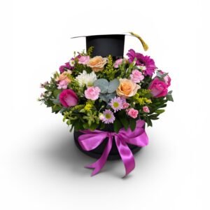 Bouquet of colorful flowers in a black hat box tied with a pink ribbon and a graduation cap on top with a gold tassel